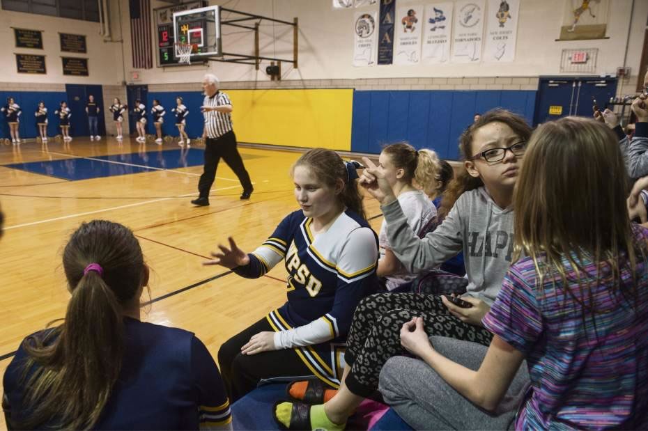 WPSD cheerleader Colleen McHale, center, hangs out with her friends on the bleachers during a basketball game on the school's home turf in Edgewood on Thursday, Feb. 4, 2016. Photo by Stephanie Strasburg, Tribune-Review
