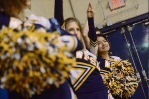 WPSD cheerleaders Krista Foster, center, and Jia Fei Reeves, right, cheer on their home court in Edgewood during a basketball game on Thursday, Feb. 4, 2016.